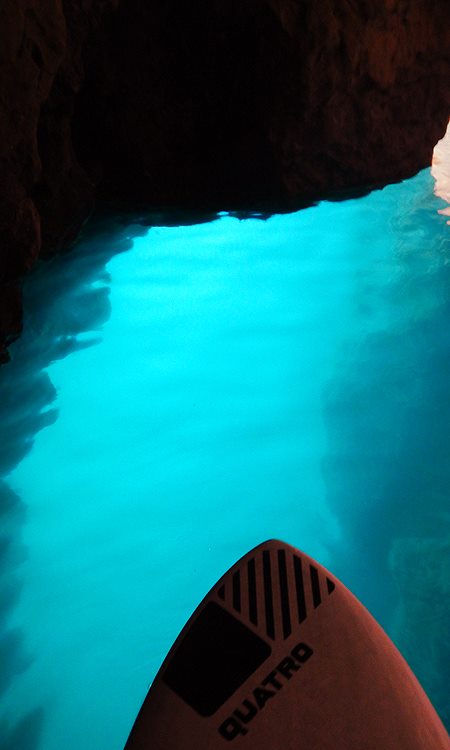 Het zonlicht licht het zeewater in de grotten op.